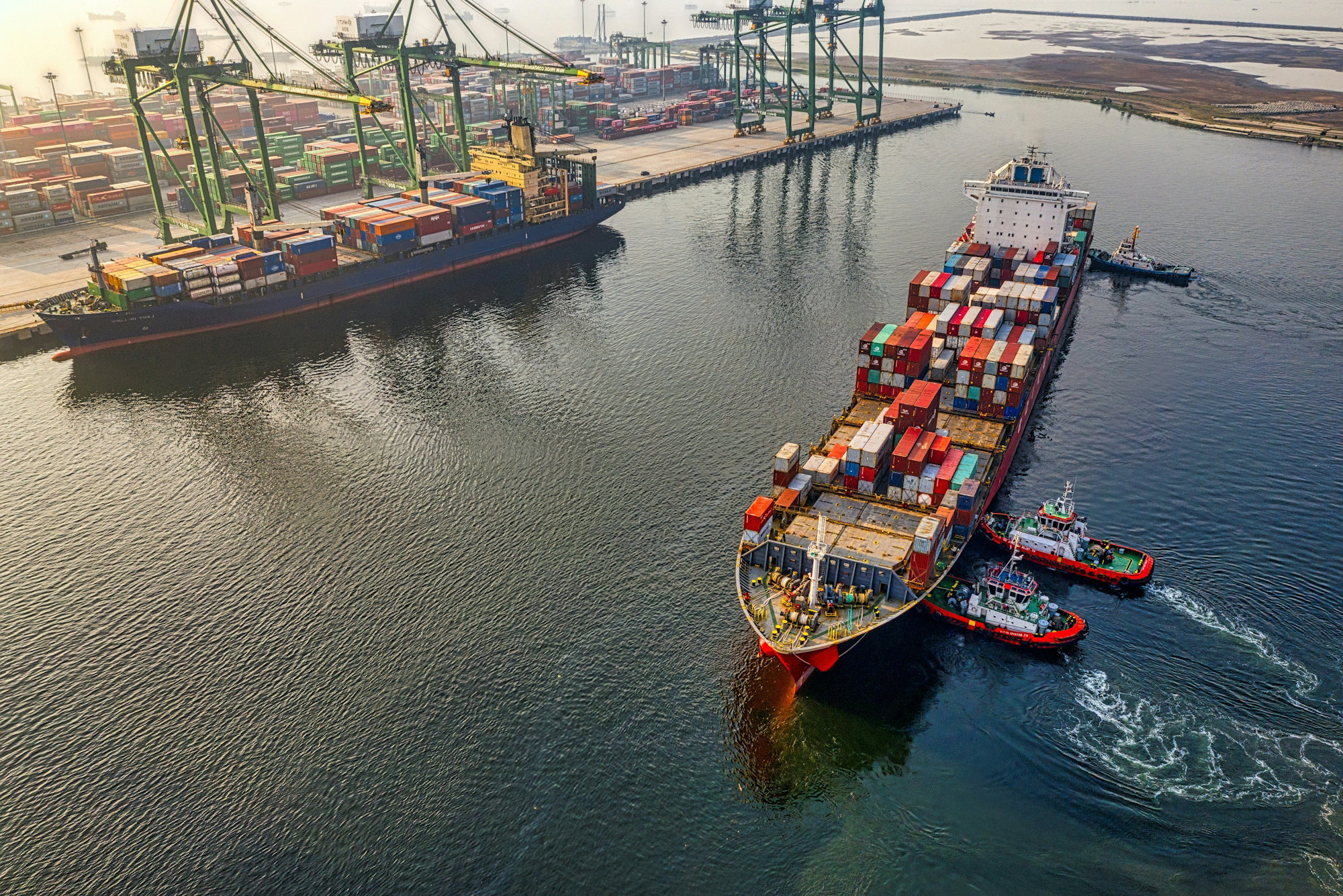 red-and-blue-cargo-ship-on-body-of-water-during-daytime.jpg red and blue cargo ship on body of water during daytime